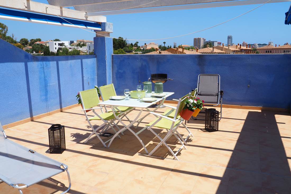 The terrace at La Estrella with the table laid under the blue awning and the Peñón de Ifach behind