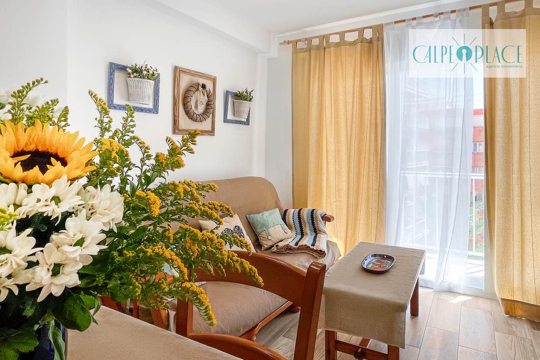 Salón comedor de Azul con las cortinas amarillas y flores sobre la mesa