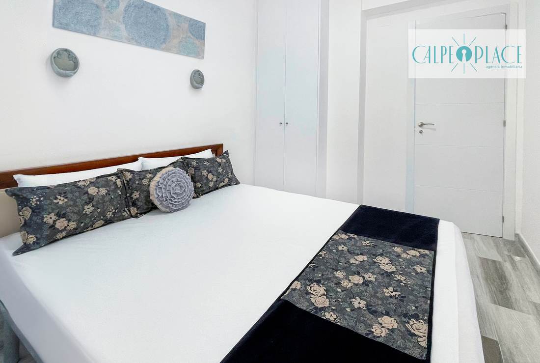 Dormitorio con cama de matrimonio y cabecero de madera
