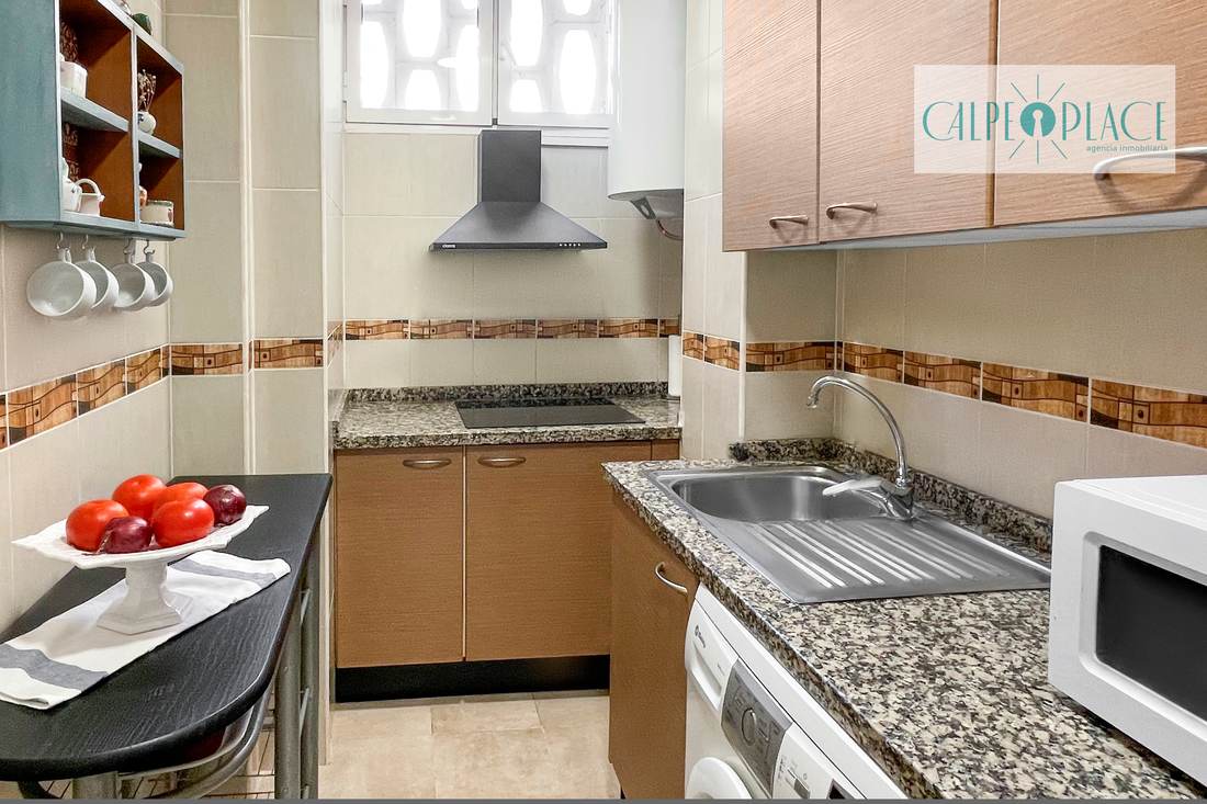 La cocina completa, con horno, campana y mesa auxiliar