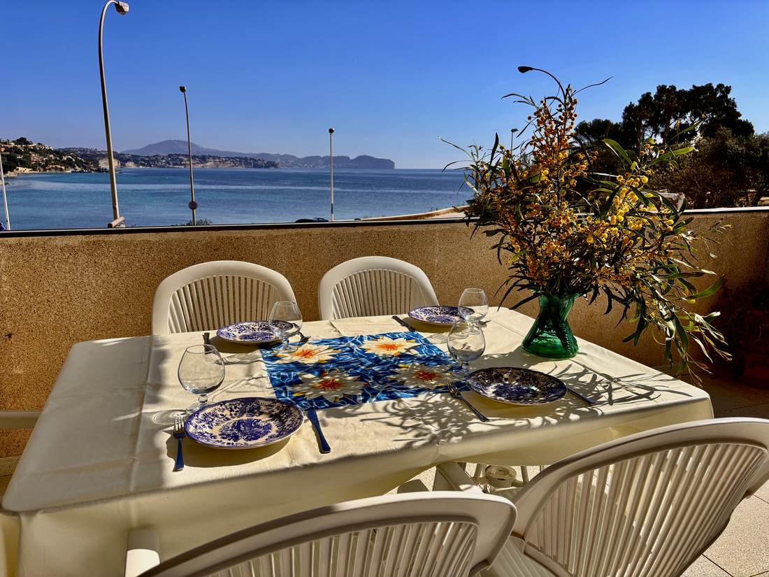 Mesa puesta en la terraza, con la bahía al fondo