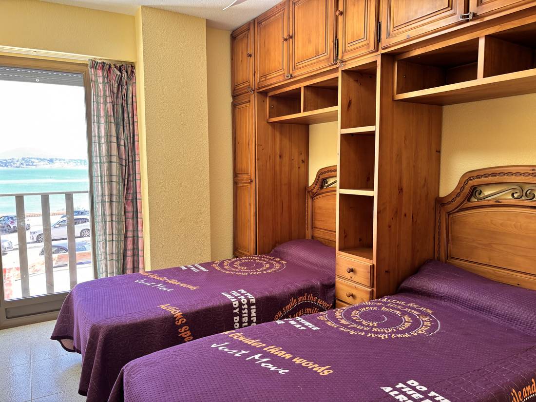 Dormitorio con dos camas y el mar por la ventana