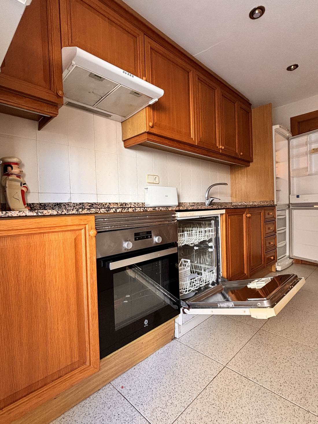 Cocina independiente con horno y muebles de madera