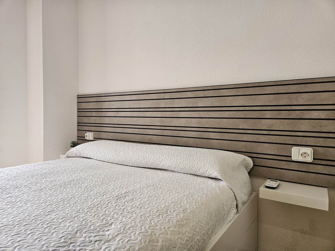 Cama doble con el cabecero de listones de madera