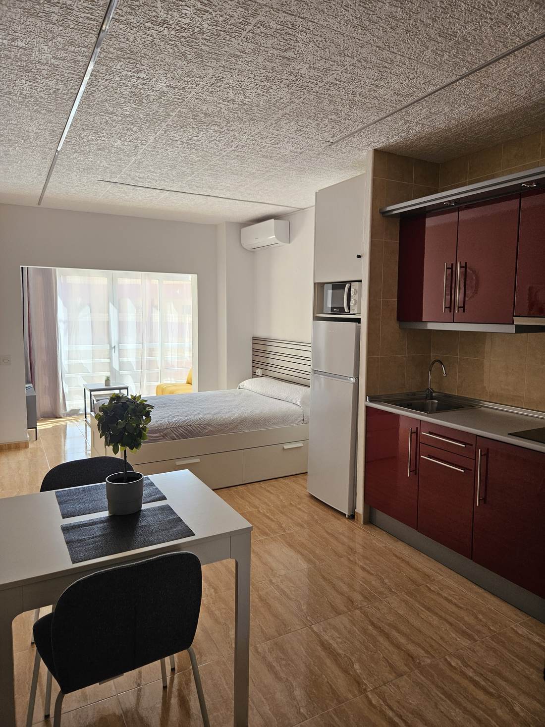 El estudio desde la entrada: mesa, cocina y ventanal