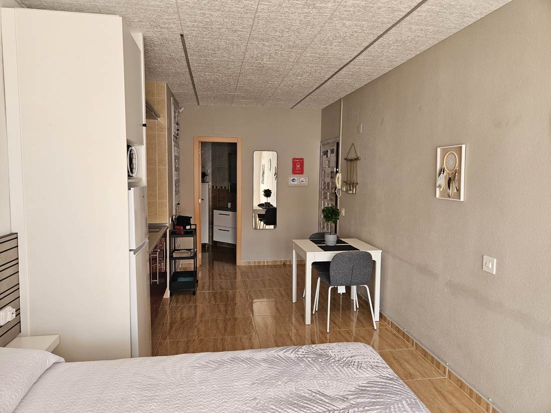 El estudio visto desde la cama, con la mesa y la ventana