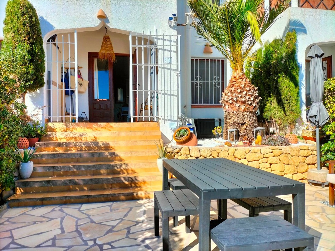 Entrance to the bungalow up the steps, with plants on either side