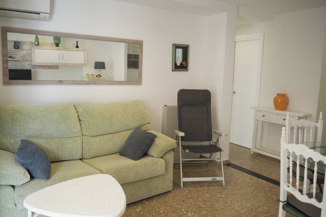 Living room with sofa, armchair and the long mirror on the wall