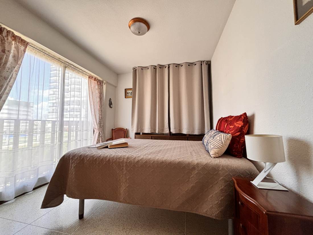 Dormitorio con cama de matrimonio y colcha marrón