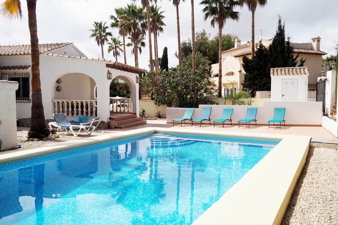 La piscina de Carrió con la villa y su naya de arcos al fondo, entre palmeras