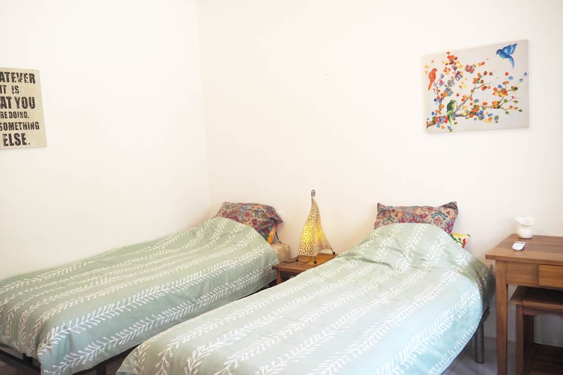 Dormitorio con dos camas individuales y colchas verdes