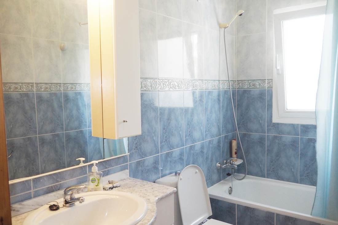 Segundo baño, en azul, con bañera y lavabo de mármol
