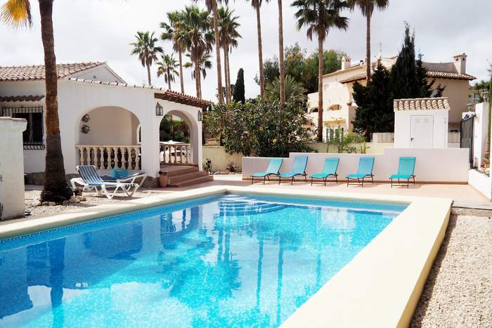 La piscina de Carrió con la villa y su naya de arcos al fondo, entre palmeras