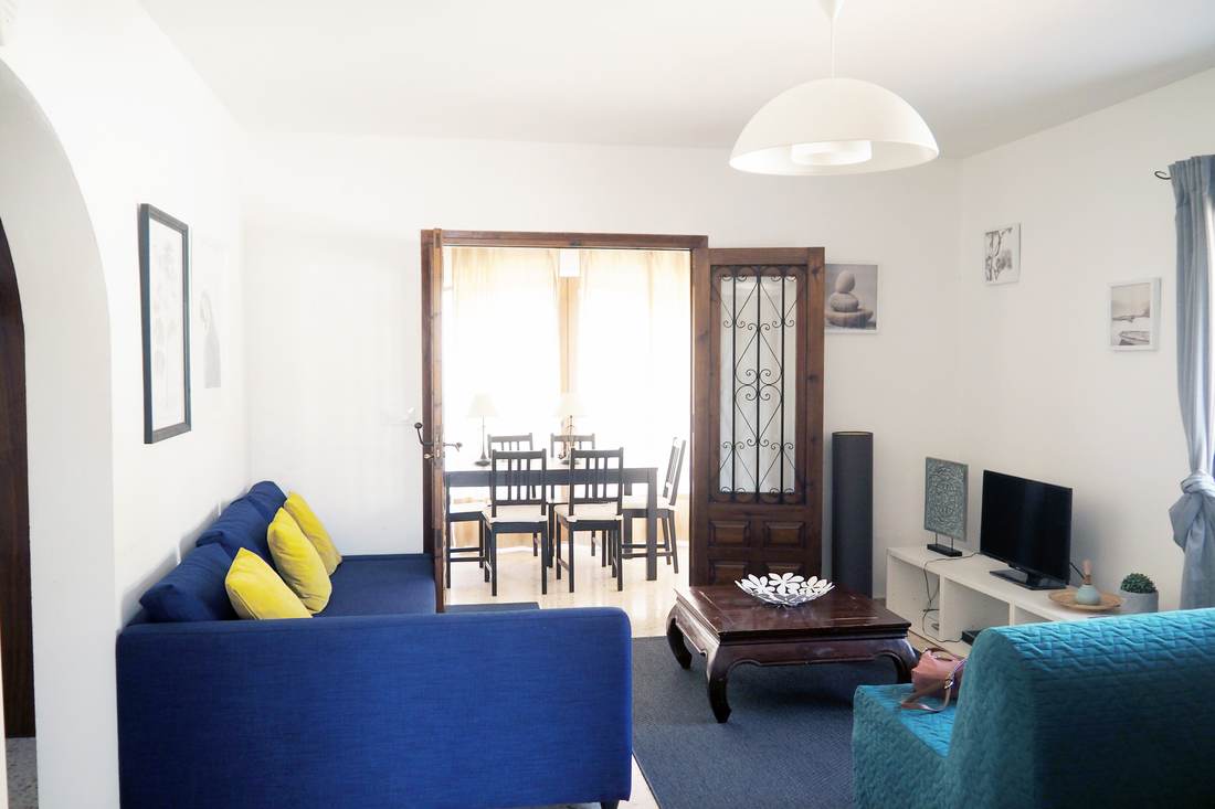 Salón-comedor de Casa Clara con los sofás azules y la mesa de comedor al fondo