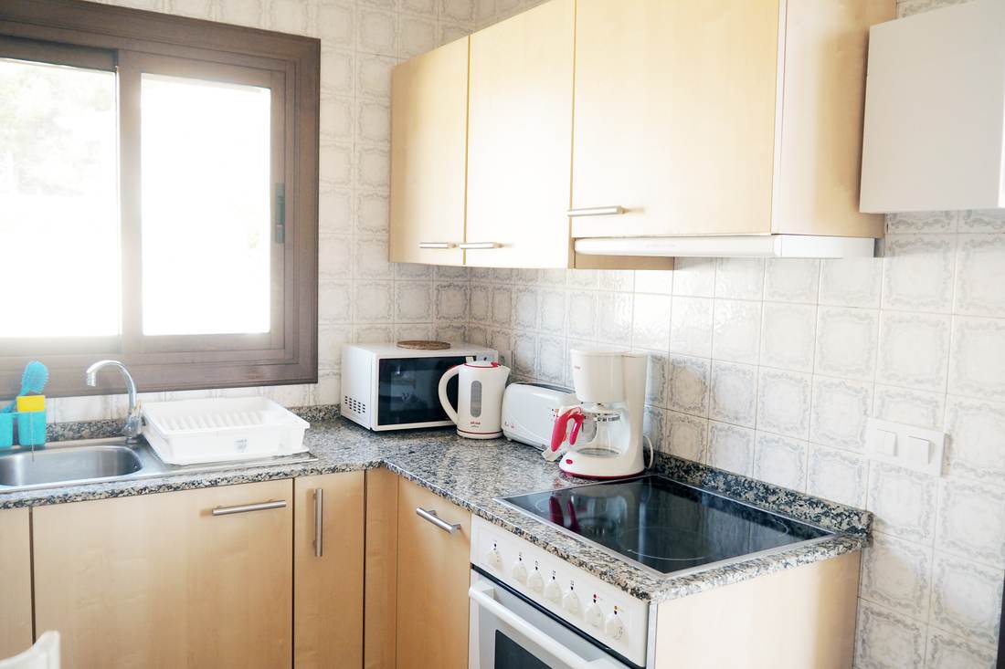 Cocina con horno, vitrocerámica y ventana al jardín