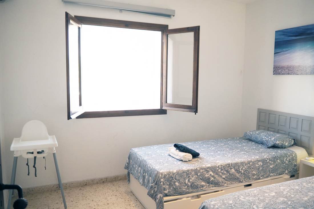 El dormitorio de dos camas visto desde la ventana, con una trona