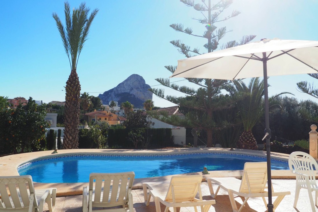Sun loungers and parasol by the pool, with the Peñón behind