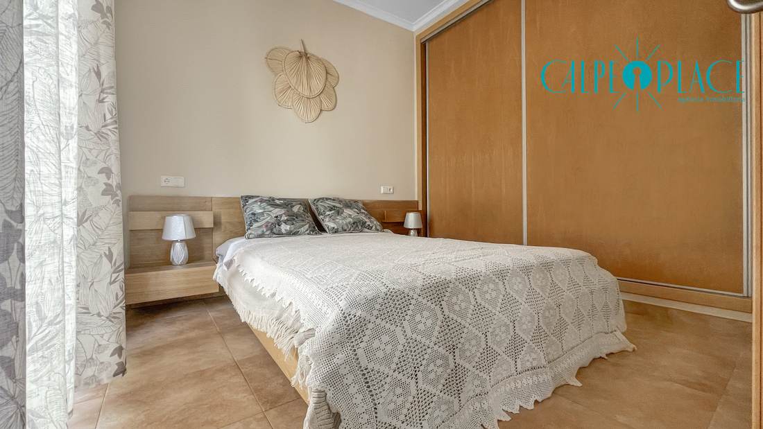 Dormitorio con cama de matrimonio y colcha de ganchillo