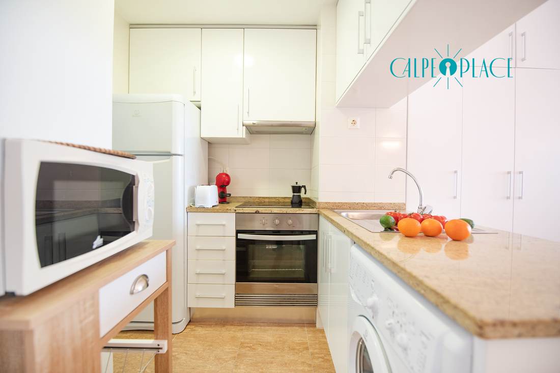 Separate kitchen with microwave, oven, washing machine and granite worktop