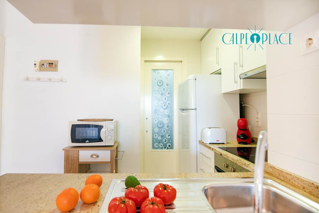 The kitchen from the other side, with the fridge and fruit on the worktop