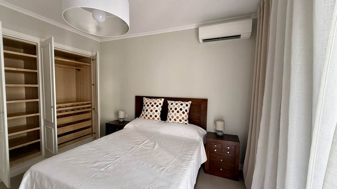 Bedroom with two single beds and an open wardrobe