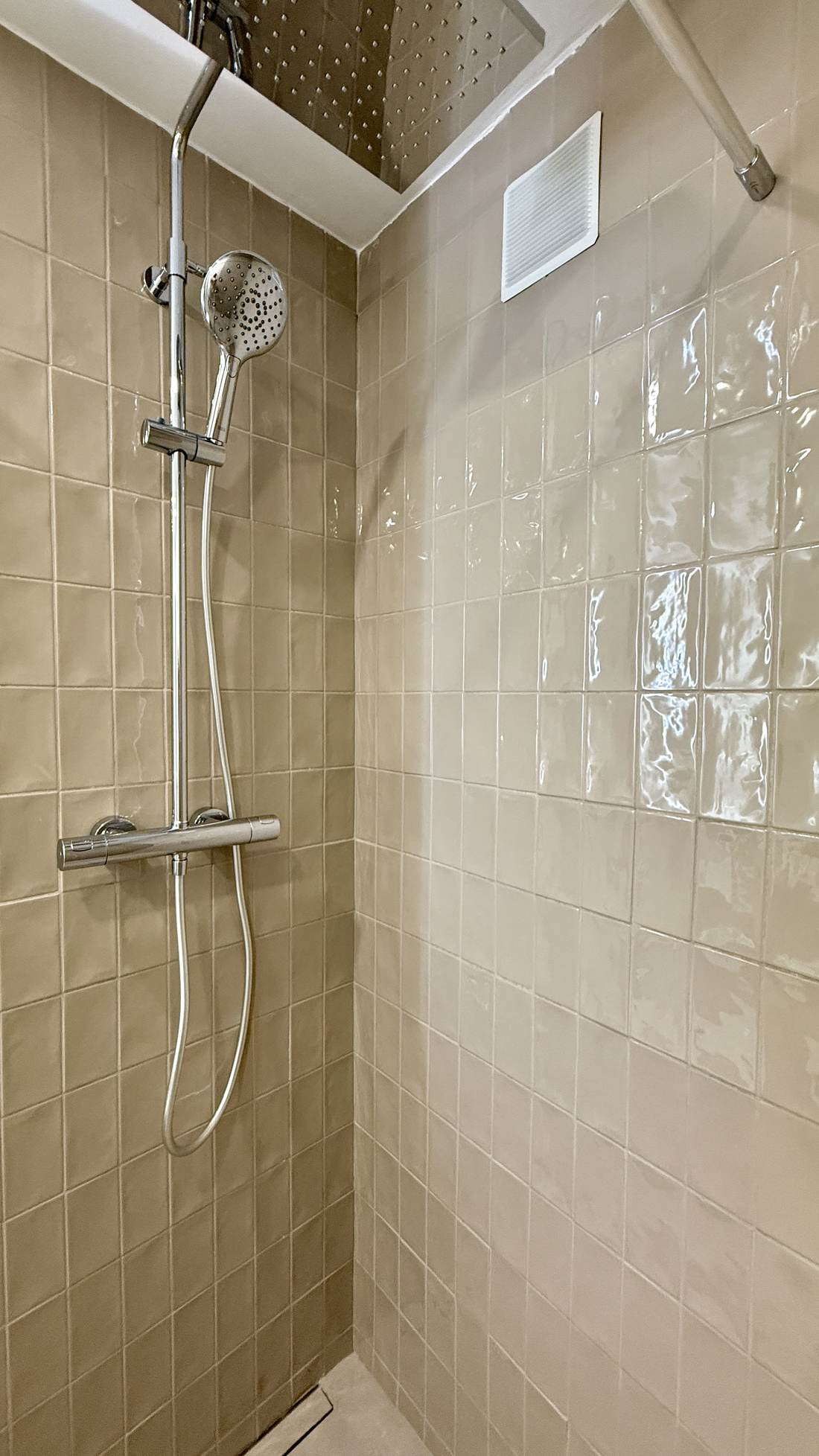 Shower with a screen and sand-coloured tiles