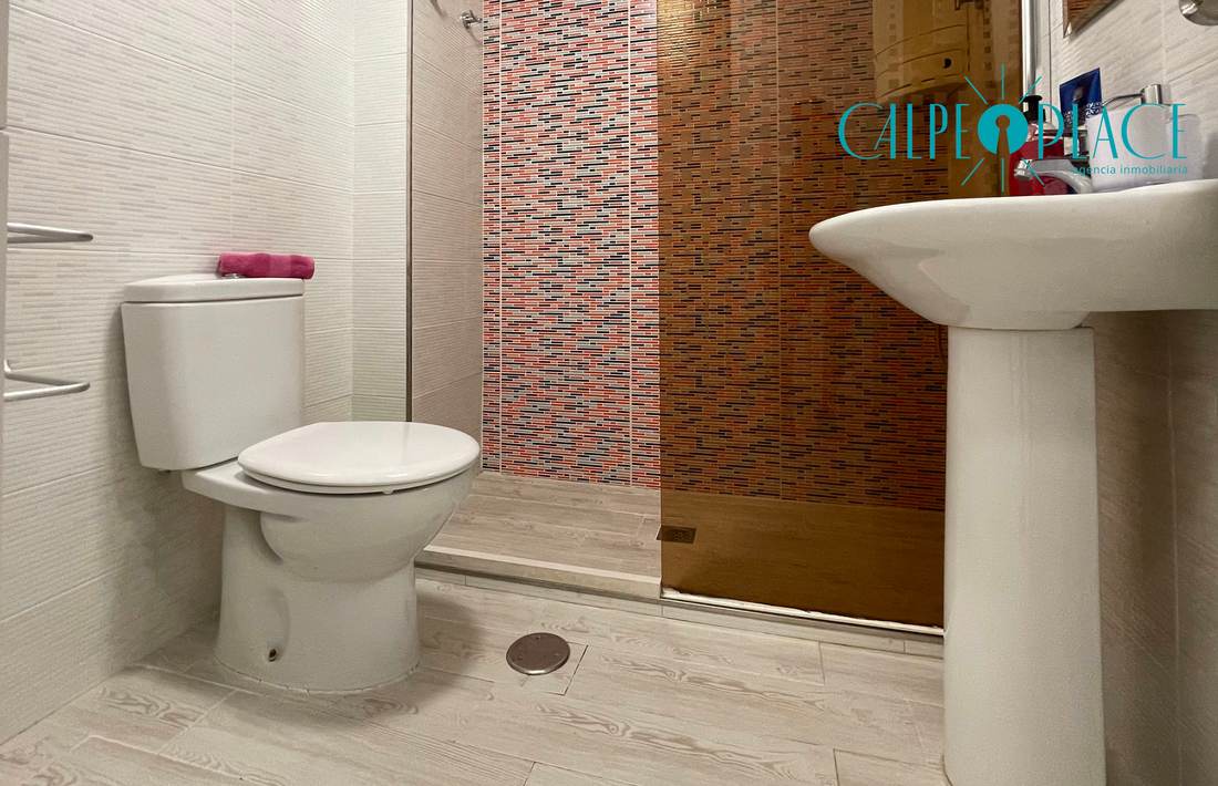 Baño con lavabo, inodoro y mampara