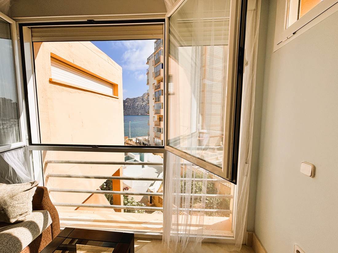 Galería acristalada con la ventana abierta y el Peñón de Ifach al fondo