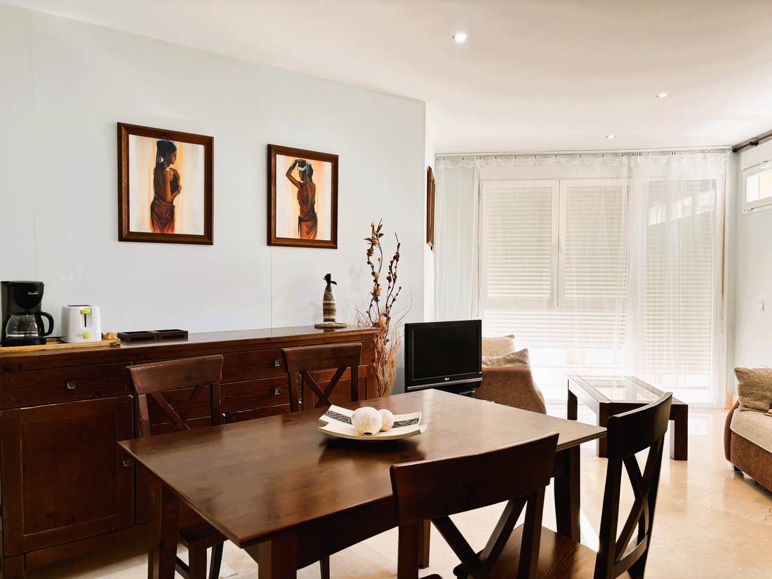 Rincón del comedor con la cómoda de madera y la mesa puesta