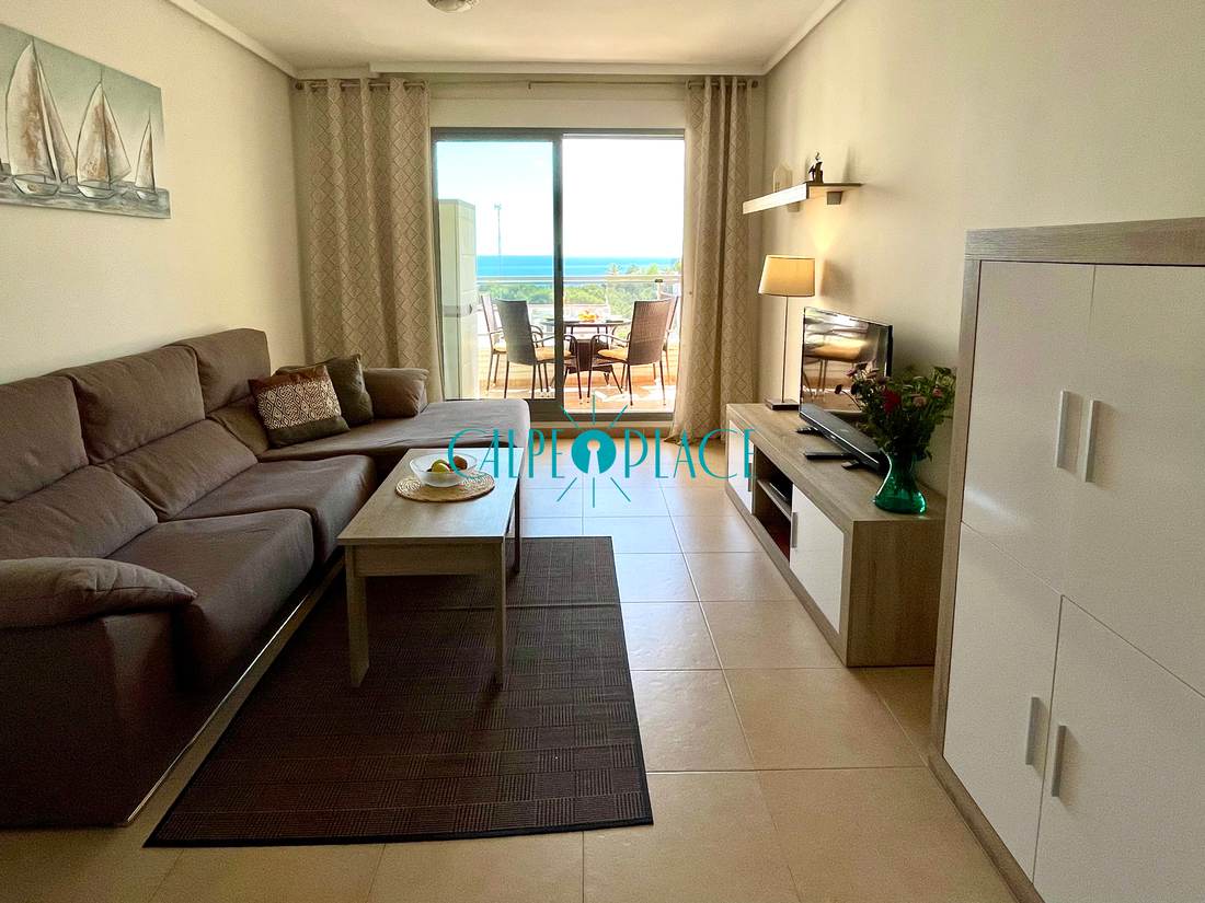 Salón de Menta con el sofá rinconera beige, la mesa baja y el mueble de televisión