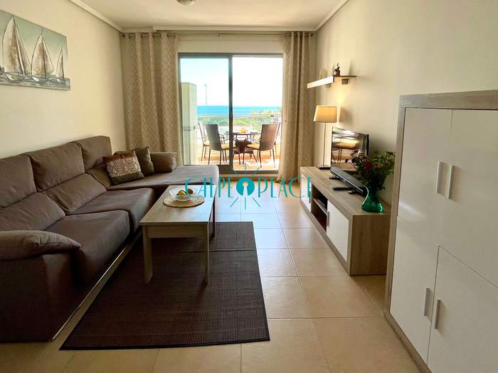 Salón de Menta con el sofá rinconera beige, la mesa baja y el mueble de televisión
