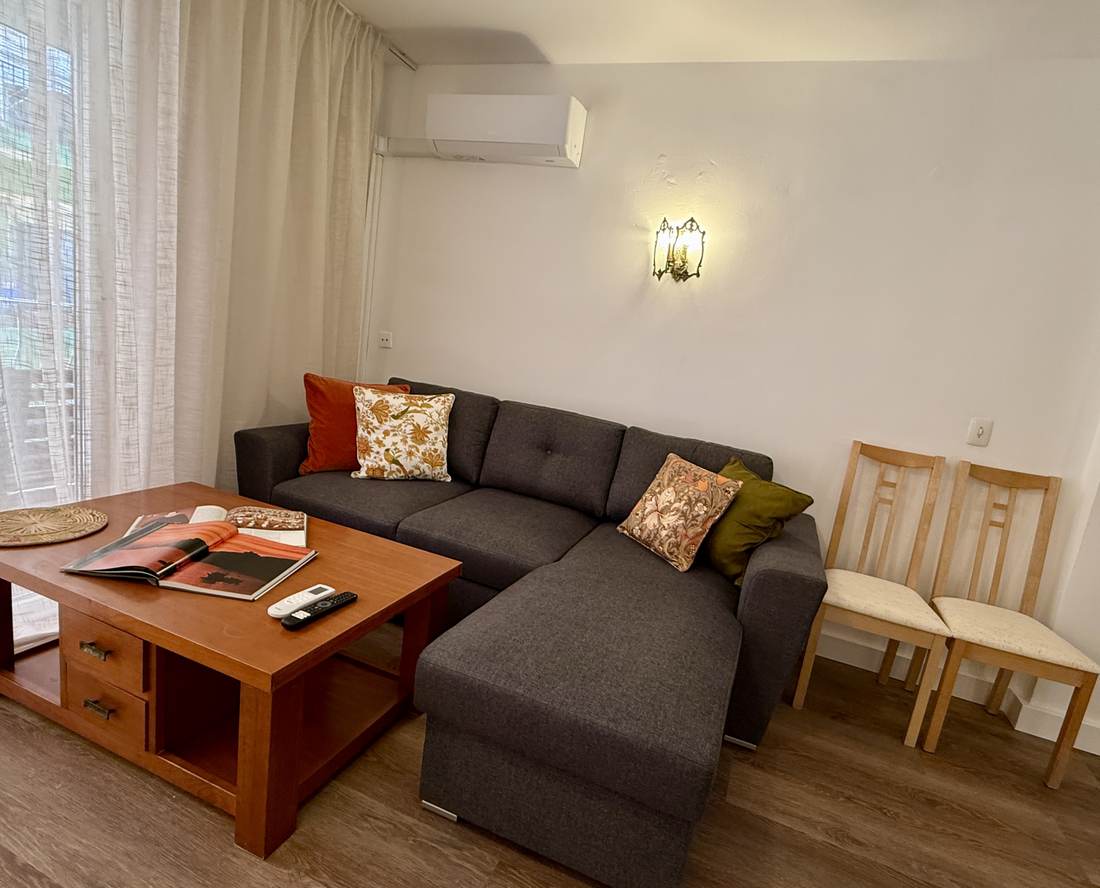 Sofá chaise longue del salón, con la mesa baja de madera