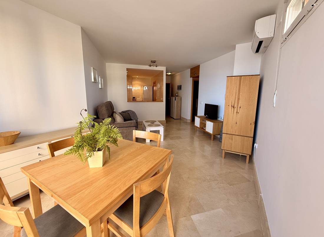 Wooden dining table with the living room behind