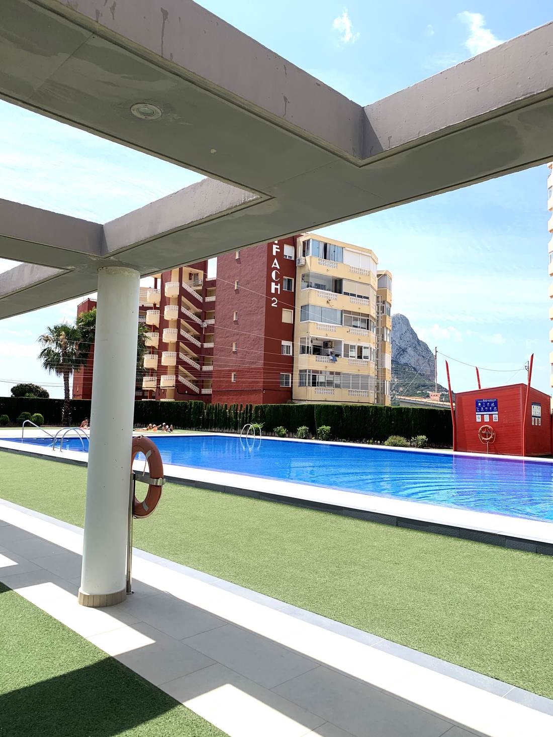 The building's pool under the white pergola
