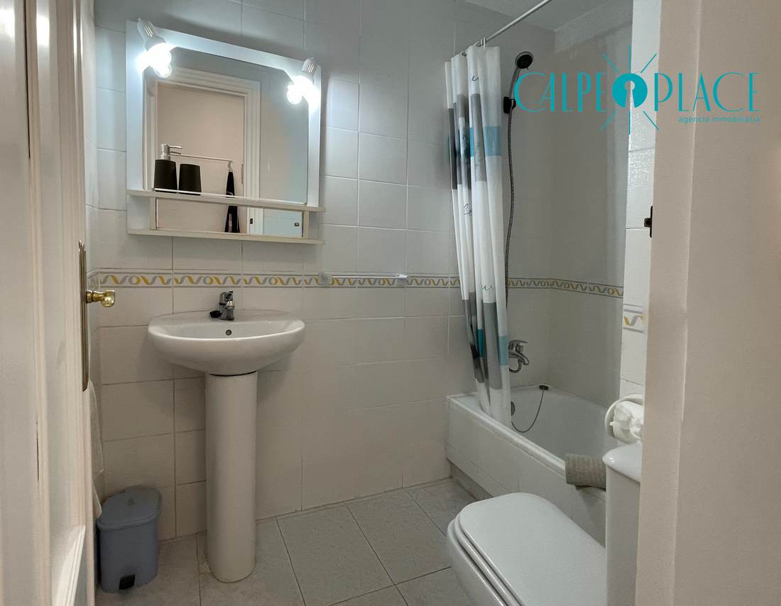Baño con bañera, lavabo y espejo