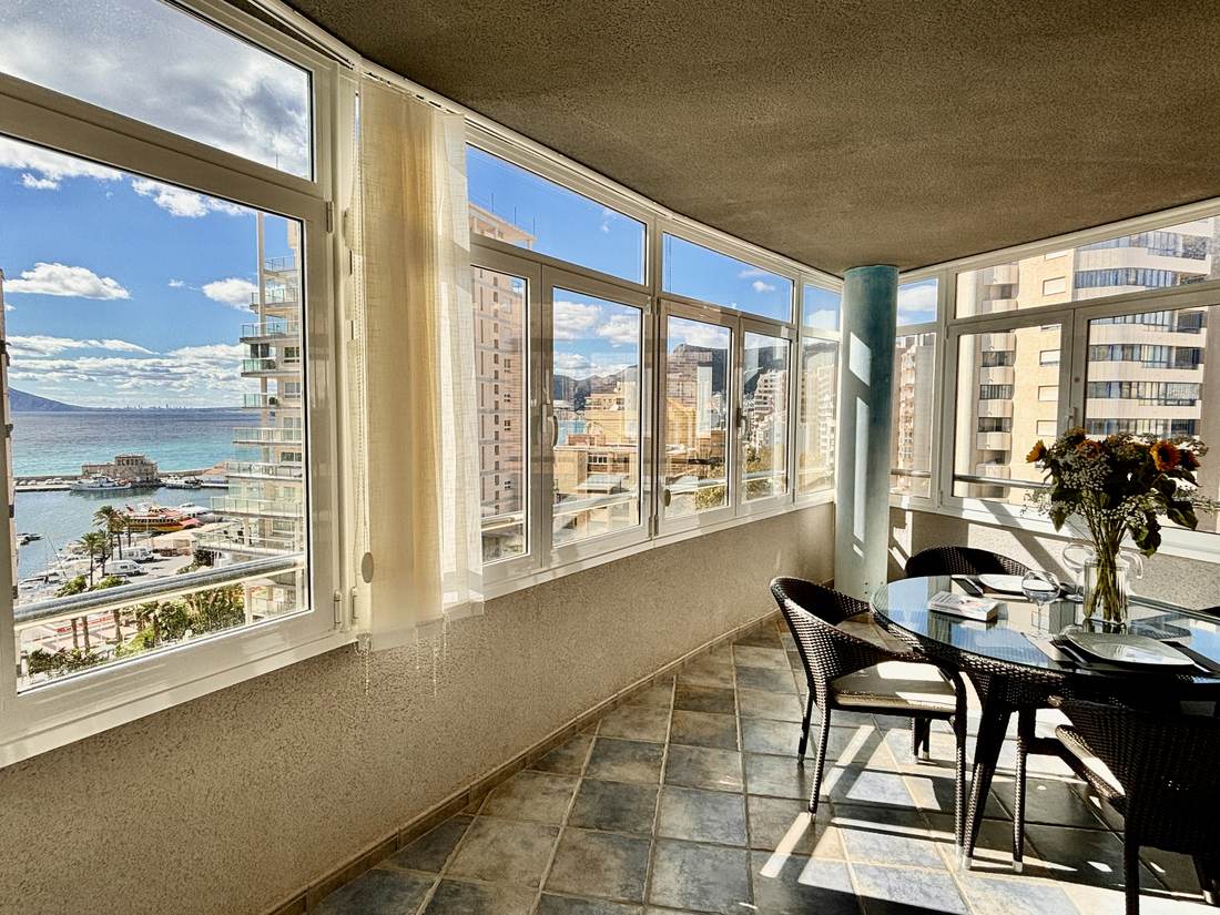 Galería acristalada con vistas al mar y a los edificios de la bahía