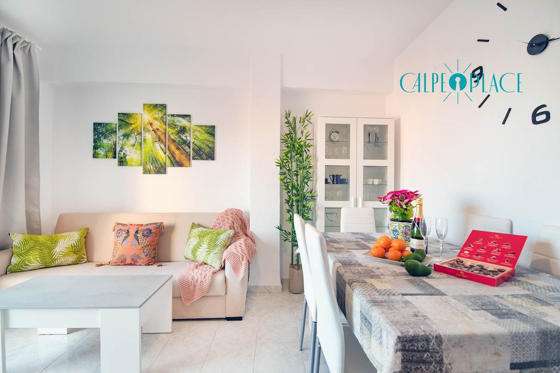 The living room at Tucán with the white sofa, the dining table and the door to the terrace