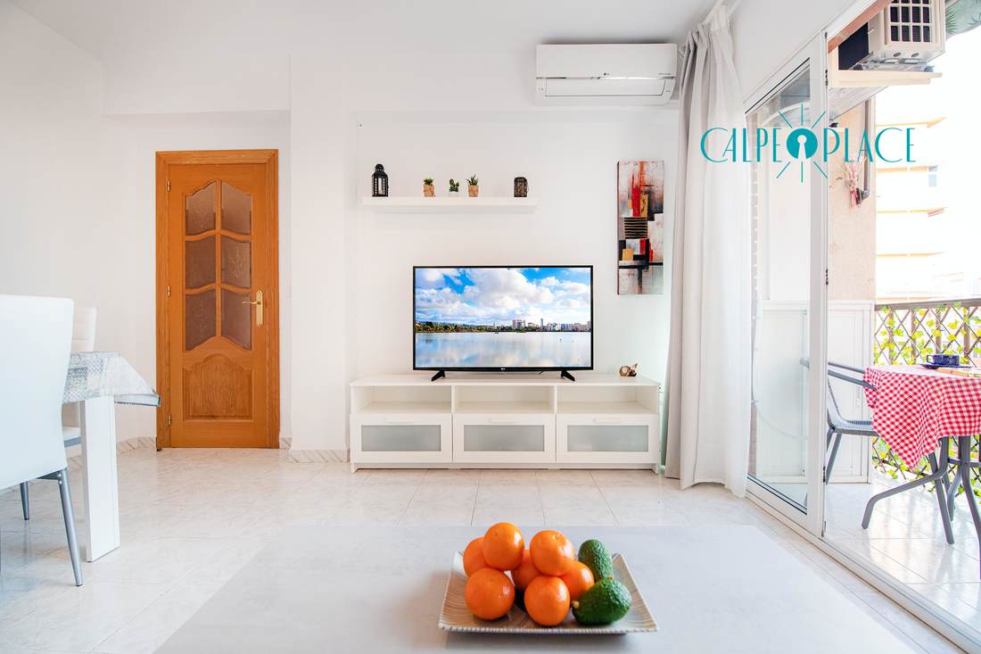 The living room with the TV and the way out to the terrace
