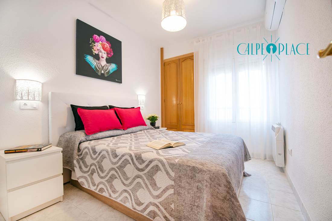Double bedroom with red cushions and the picture above the headboard