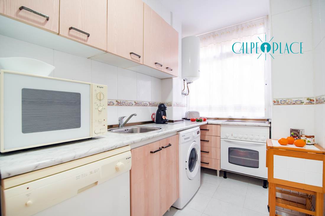 Kitchen with washing machine, oven and microwave
