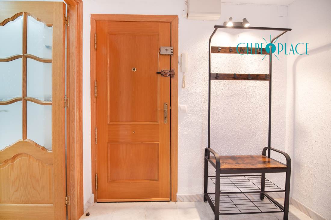 The entrance, with the wooden door and the coat stand