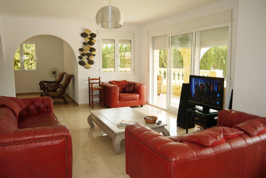 Salón con sofás de cuero, mesa baja y televisión