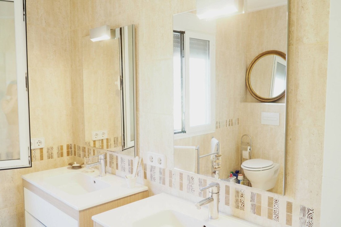 Baño con doble lavabo y espejos