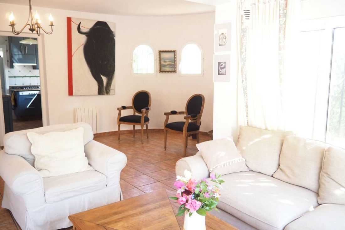 Salón con sillones blancos y el cuadro del toro