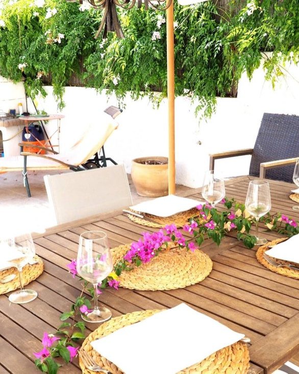 A table laid in the arbour at Villa Ricarlos, in the shade of the bougainvillea