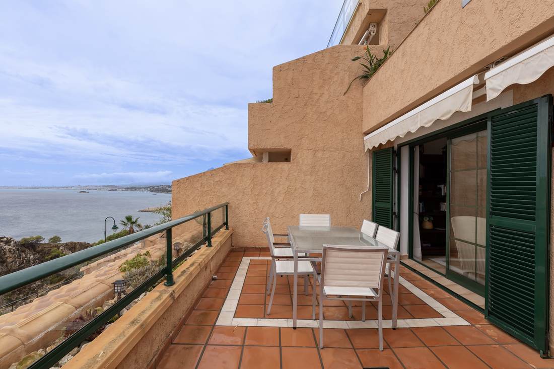 Terraza con la mesa y las sillas y el mar abierto delante
