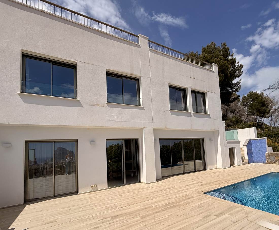 Fachada del chalet de Cosentari con la piscina desbordante delante
