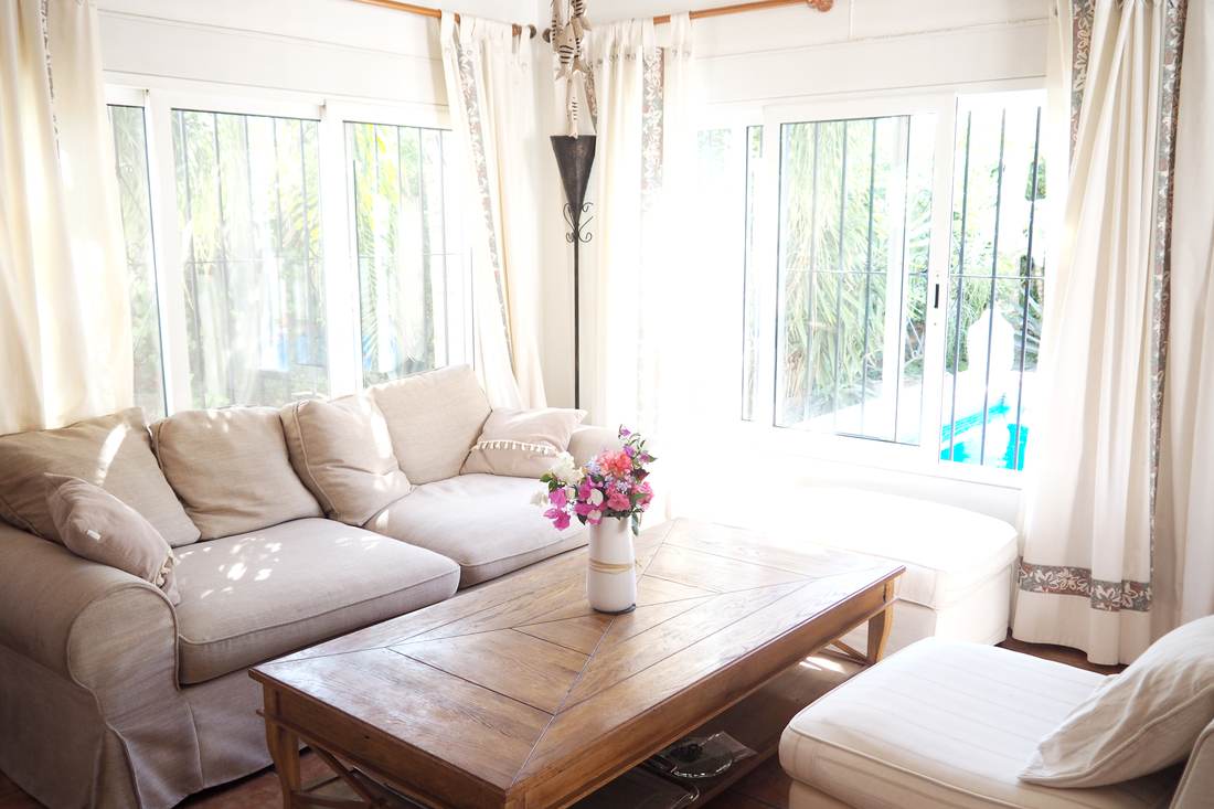 Salón con los sofás blancos y la mesa baja de madera