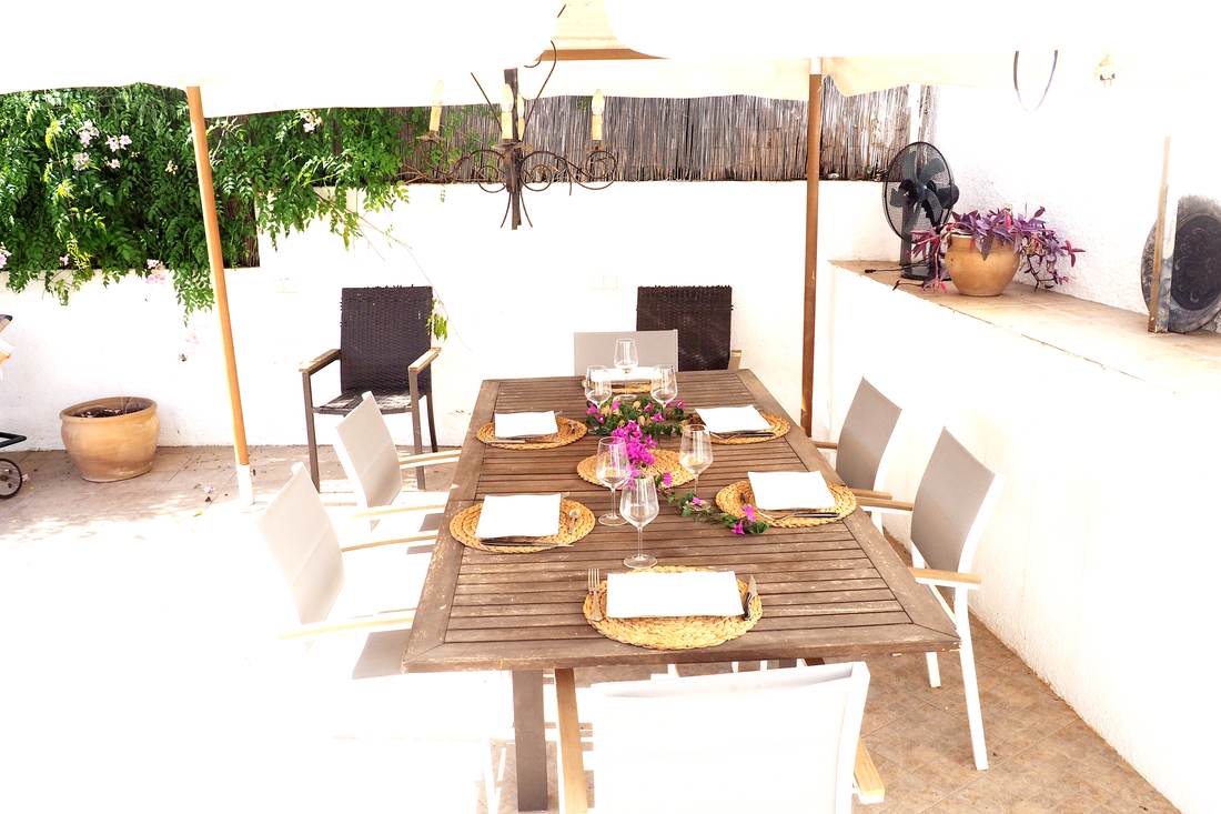 Mesa de comedor al aire libre bajo la pérgola